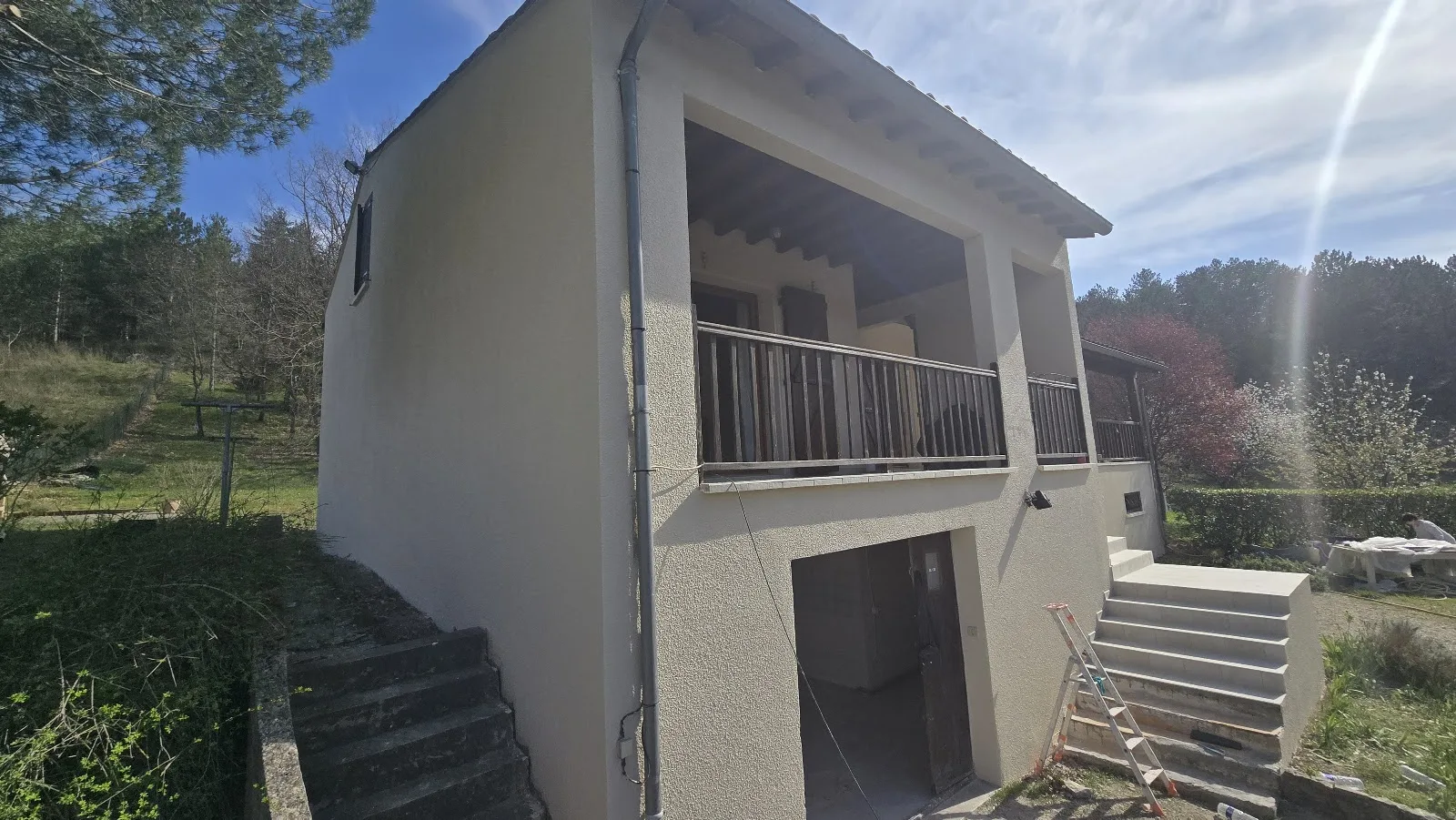 Enduit clair et garde-corps repris sur une maison à étage